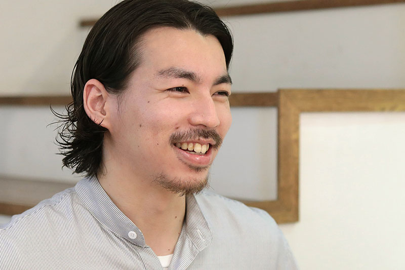 レジで笑顔の山内さん（横顔）